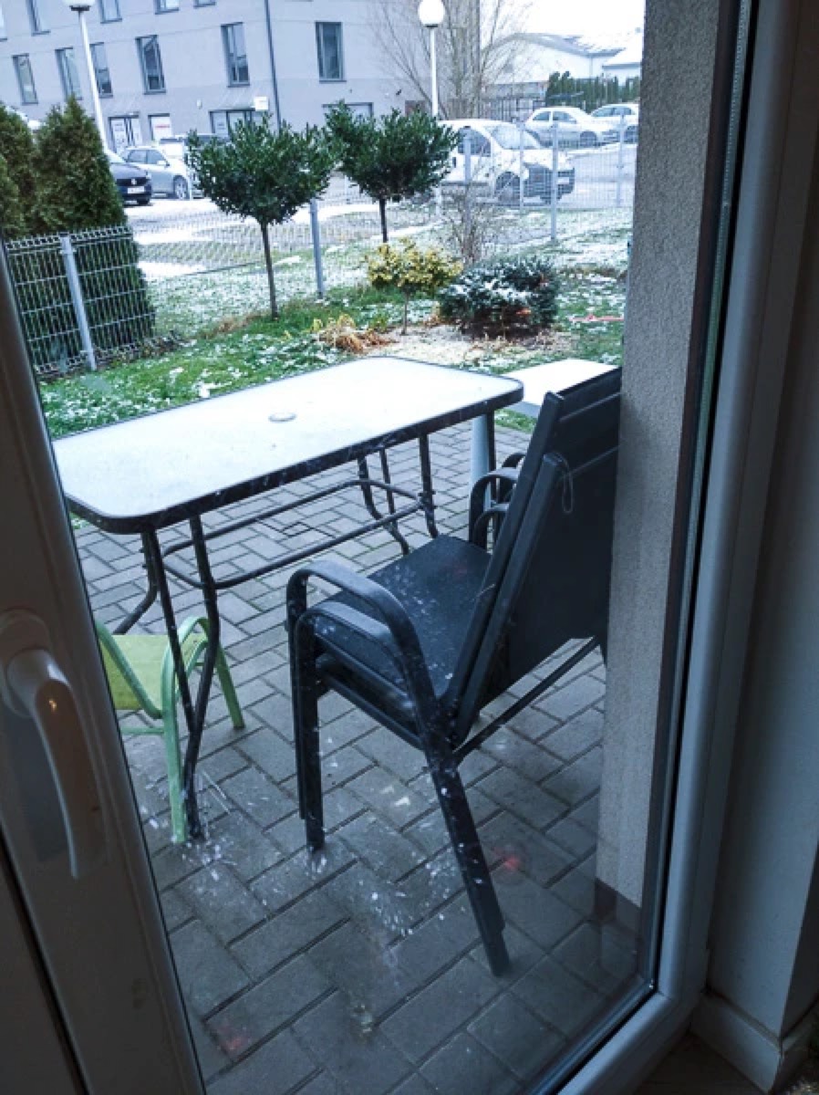 Czyste okno tarasowe po drugim myciu Hobotem 2S, wyraźnie widoczny taras, stół i ogród