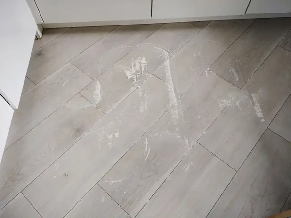 Podłoga w kuchni z resztkami mąki po pierwszym przejeździe robota w trybie na sucho