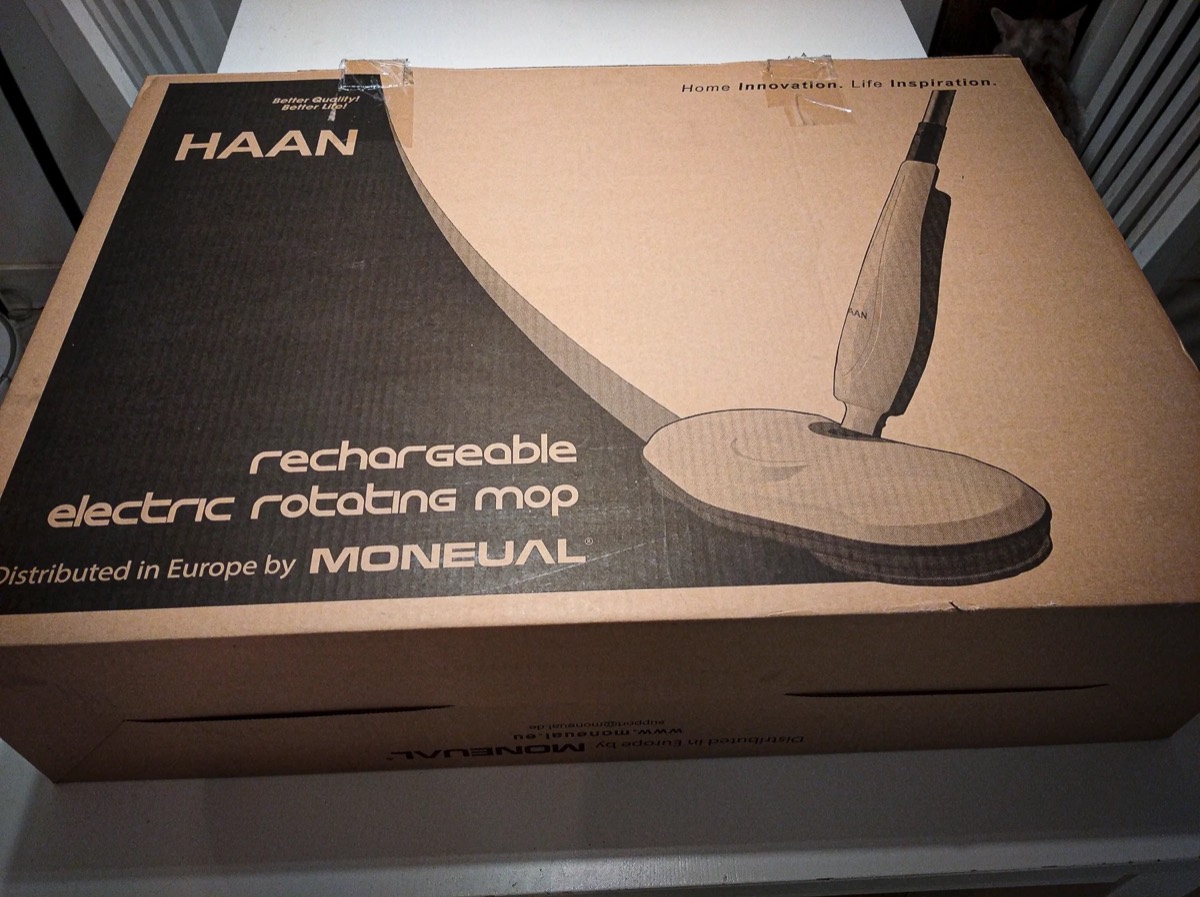 Brązowe tekturowe pudełko z napisem HAAN rechargeable electric rotating mop, distributed in Europe by Moneual